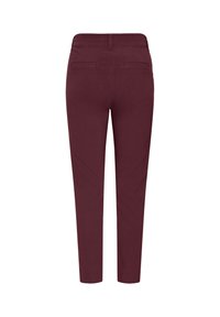 Pantalon bordeaux ajusté vu de dos, avec deux poches passepoilées à l’arrière et une coupe moulante, longueur cheville. Aucun personne ou arrière-plan visible.