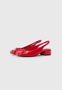 Röda patentläder slingback-skor med rund tå och rosettdetalj. Låg klack och öppen baksida för enkel påtagning. Slät, glänsande yta.