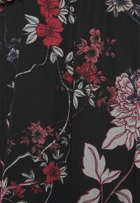 Tissu noir avec imprimé floral rouge, blanc et rose comportant des feuilles et des motifs floraux détaillés.