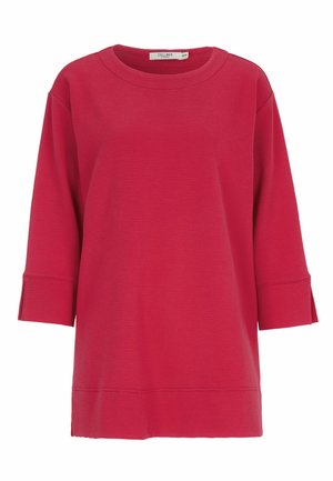 Punainen ribbineulottu collegepaita, jossa pyöreä pääntie, kolme neljäsosaa hihat ja sivuleikkaukset helmassa. Pehmeä ja teksturoitu kangas.