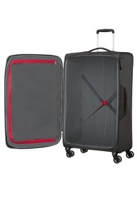 Valise noire à roulettes avec doublure grise, dotée d'une poche en mesh avec bordure rouge, de sangles réglables pour sécuriser le contenu et d'une poignée rétractable.