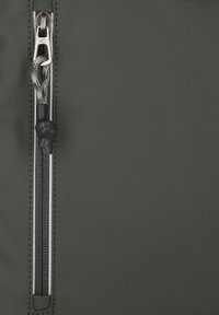 Donkergroene ritstas met een gestructureerd oppervlak, een metalen rits en een stoffen lus met een geknoopt zwart accent.