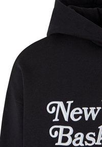 Fekete kapucnis pulóver, fehér hímzett "New Basket" szöveggel. Az anyag puha, texturált felületű, és laza szabású.
