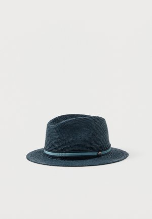 Chapeau fedora tissé bleu marine avec un ruban rayé bleu assorti autour de la base de la couronne sur un fond blanc uni.