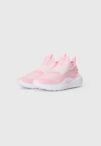 Pár ružových teniskov Nike na slip-on s bielymi podrážkami a elastickými pásmi cez vrch, zobrazené na svetlom jednoduchem pozadí.