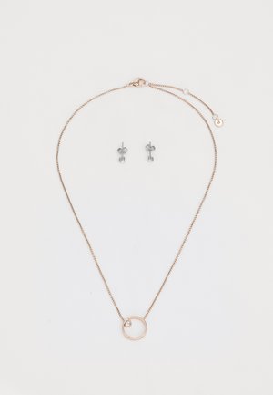 Collana a catena in oro rosa con un pendente circolare che presenta una piccola pietra preziosa trasparente; accompagnata da orecchini a bottone in argento con punte rotonde.