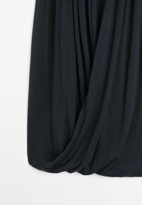 Close-up of black fabric draped with soft folds against a white background.