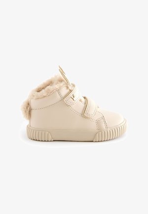 Beige leren peuterschoenen met nepbontafwerking, klittenbandsluiting, een ronde neus en een gestructureerde rubberen zool met uitstekende ribbels.