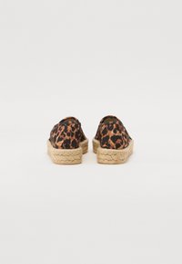 Espadrilles avec un dessus en tissu imprimé léopard, semelle en jute naturel tressé et design à bout arrondi. Style léger et décontracté.