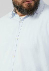 Lichtblauw overhemd met knopen, gemaakt van textuurstof, met een spread collar en knopen in een contrasterende lichte kleur.
