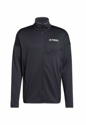 Black zip-up jacket made of soft fabric, features a high collar, full zip front, and a small chest pocket. Logo printed on the left side.