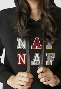 Felpa nera con lettere ricamate multicolori "NAF" e decorazioni. Presenta un cordino con una finitura piatta e testurizzata.