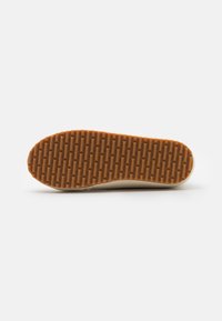 Rubber shoe sole with a textured, patterned surface, featuring a brown color and rounded toe design, smooth edges, and a subtle lip.