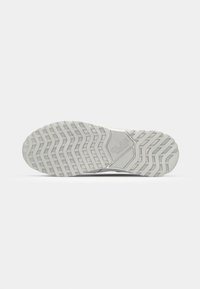Semelle d'une basket blanche avec un motif de semelle en zigzag et une section rectangulaire texturée au centre.