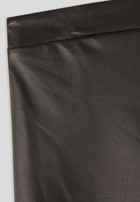 Tessuto in finta pelle nera con una texture liscia e opaca. Presenta un bordo ripiegato e una leggera lucentezza, mostrando un colore e una finitura uniformi.