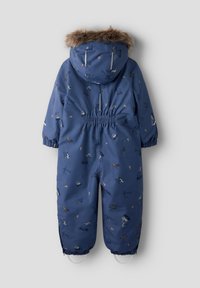 Mono de nieve azul para niños con capucha, que incluye un ribete de pelo sintético, cintura elástica y un patrón de vehículos de construcción. Material impermeable.