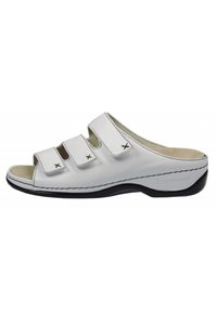 White leather slip-on sandals with three adjustable straps, black accents, and a contoured footbed. Features stitched detailing and open toe.