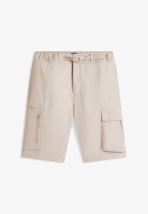 Beige knee-length cargo shorts with elastic waistband, adjustable belt, zippered pocket on left leg, and flap pocket on right leg.