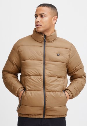 Braune Pufferjacke, gestepptes Design, hoher Kragen, durchgehender Reißverschluss, Fronttaschen, glatte Textur, mit schwarzen Akzenten und Logopatch auf der Brust.