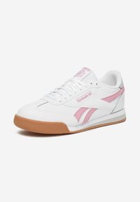 Scarpa sportiva bianca con accenti rosa e suola in gomma. Presenta una tomaia in pelle e sintetico, lacci e dettagli del logo sulla linguetta e sul lato.