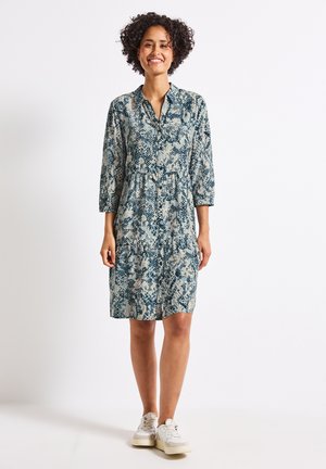 Knopfkleid aus leichtem Material mit einem blau-beigen Schlangenmotiv, 3/4-Ärmeln, gestuften Design und einer lockeren Passform.