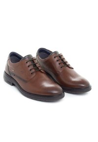 Zapatos de cuero marrón con cordones y un acabado suave, punta redondeada y acentos de color oscuro. Suela de goma con forro interior texturizado.