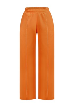 Pantalons de survêtement larges orange avec une taille élastique, présentant des détails de couture blanche sur les côtés et une texture lisse.