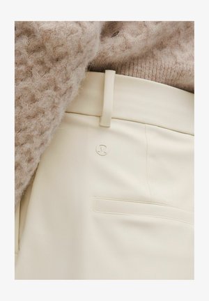 Hose in cremefarben aus glattem Stoff mit schmaler Passform. Verfügt über ein dezentes Logo, eine Seitentasche und ein flaches Taillenbund-Design.