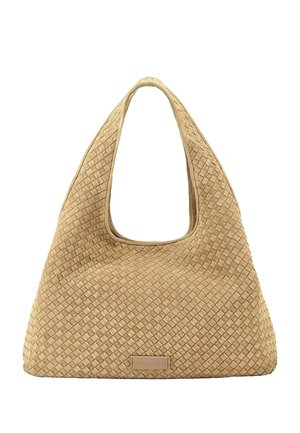 Bolso tejido beige con textura, con un asa ancha y redondeada y una etiqueta de marca rectangular en la parte inferior central.