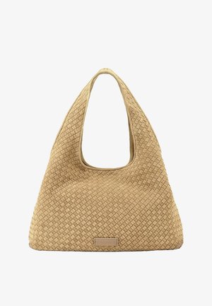 Bolso tejido beige con textura, con un asa ancha y redondeada y una etiqueta de marca rectangular en la parte inferior central.