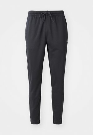 Black sweatpants made of a soft, stretchy fabric. Features an elastic waistband with drawstring and tapered legs with cuffs.