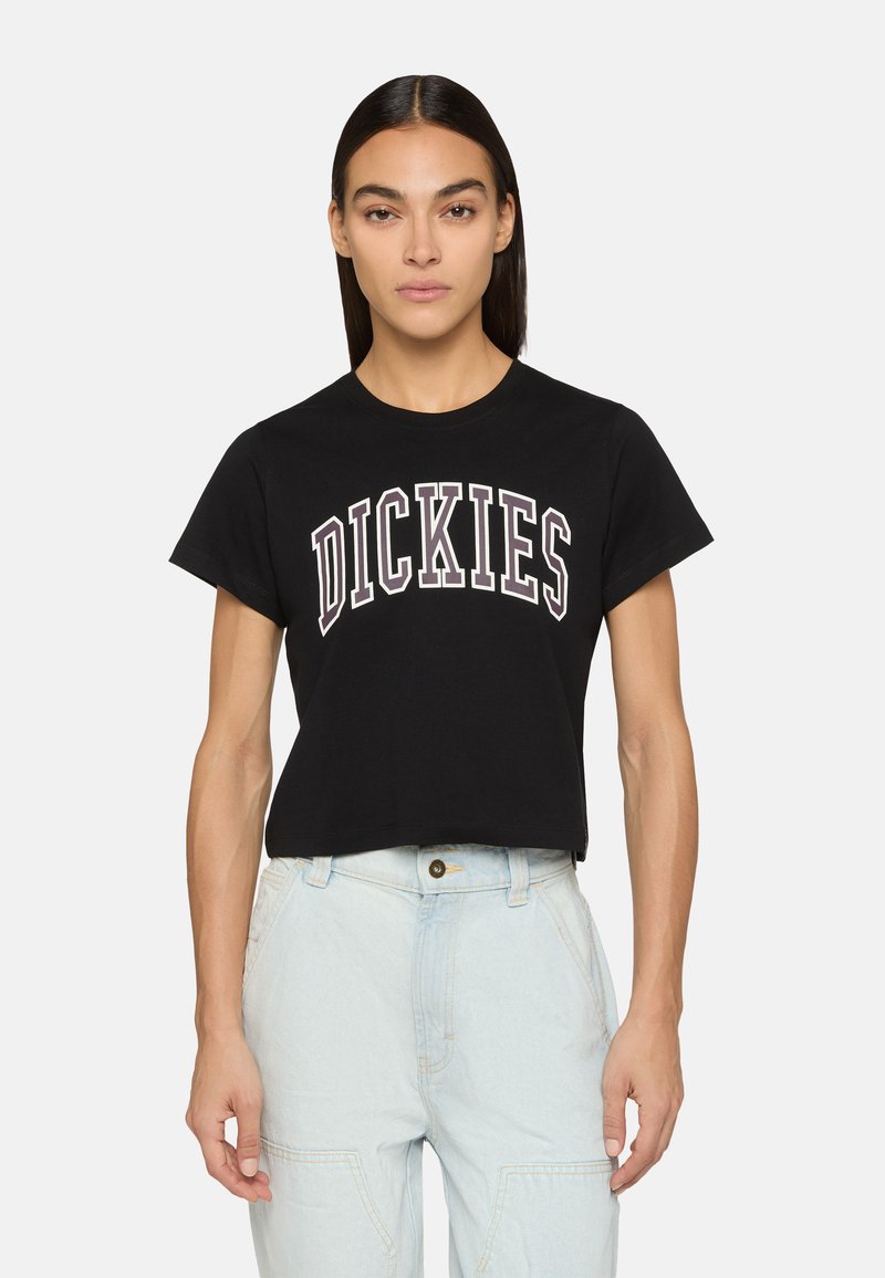 Černé bavlněné zkrácené tričko s nápisem "DICKIES" velkými, zakřivenými bílými písmeny se slabým obrysem. Klasický kulatý výstřih.