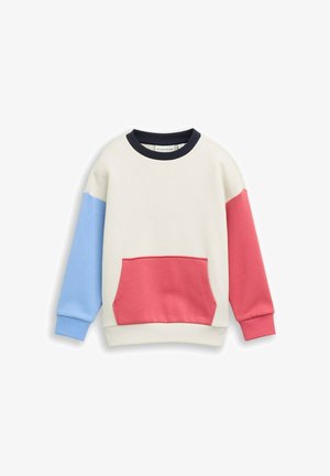Bluza z długim rękawem z kremowym korpusem, niebieskim lewym rękawem, czerwonym prawym rękawem, czerwoną przednią kieszenią i czarnym okrągłym dekoltem.