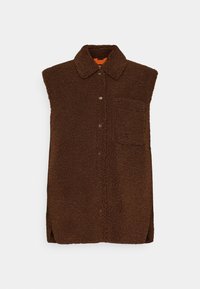 Mouwloos bruine sherpa fleece bodywarmer met knopen aan de voorkant, kraag, zak met klep op de borst en zijsplitten tegen een lichte achtergrond.