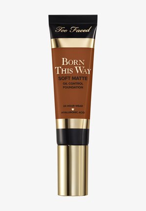 Tube van Too Faced Born This Way Soft Matte oliecontrole foundation met gouden en zwarte dop, 24 uur houdbaar, hyaluronzuur, medium diepe tint.
