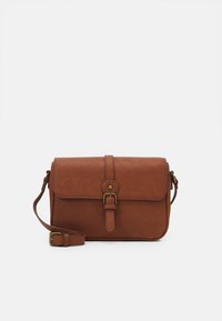 Brun læder crossbody taske med justerbar rem, forsideklap sikret af en central rem og messing spænde detaljer.