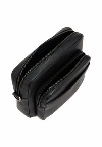 Bolso de piel negra con dos compartimentos con cremallera y un bolsillo frontal, con una textura suave y detalles de hardware en plata.