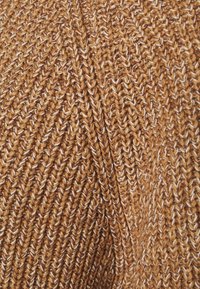 Gebreide trui stof in warm bruin met lichte accenten, met een diagonaal ribbelpatroon en een zachte, textuurrijke afwerking.