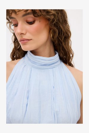 Světle modré šaty s halter výstřihem, plisovaná látka; měkká textura; volný střih, odhalená ramena; minimalistický design; žádné viditelné vzory.