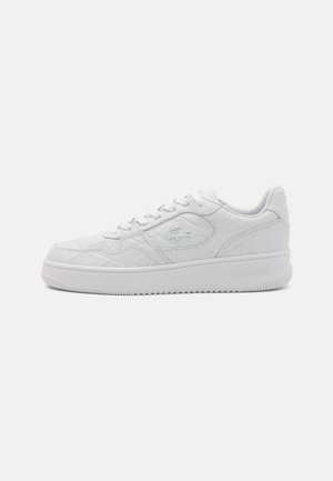 Hvid Lacoste lavtopsneaker med prægede geometriske mønstre, snørebånd og krokodillelogo på siden, sat mod en ensfarvet baggrund.