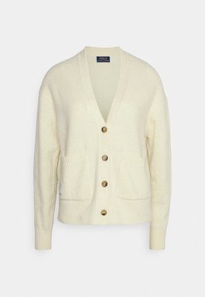 Gilet couleur crème avec col en V, manches longues, quatre boutons marron, deux poches avant, poignets et bas côtelés.
