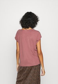 Roze kortemouwen t-shirt met een relaxte pasvorm, ronde hals en opgerolde mouwen, gecombineerd met een gestreepte donkere rok.