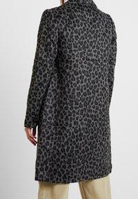Abrigo de estampado de leopardo en mezcla de lana gris y negro, con mangas largas, cuello con muesca y cierre de botón en los puños. Textura suave, hasta la rodilla.