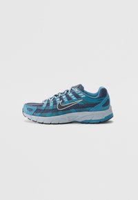 Nike bėgimo bateliai mėlynos ir žalios spalvos tinklelio su sidabro akcentais, turintys paminkštintą apykaklę, tekstūruotą padą ir patogią siluetą.