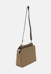 Sac à main en cuir marron avec une forme structurée, équipé d'une bandoulière amovible et de détails en métal argenté. Surface texturée.