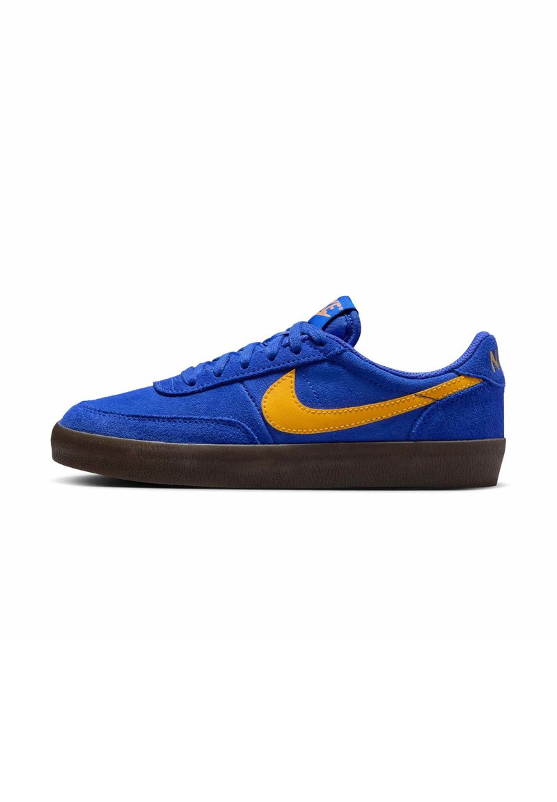 Baskets basses en daim bleu avec un swoosh jaune Nike et une semelle noire, vues de côté sur fond blanc.