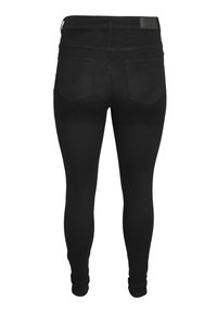 Jean noir ajusté pour femme vu de dos, avec deux poches arrière, passants de ceinture et taille haute.