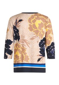 Haut à motifs floraux présentant de grandes fleurs jaunes et bleu foncé sur un fond beige, avec des manches trois-quarts et un accent rayé bleu à l'ourlet.