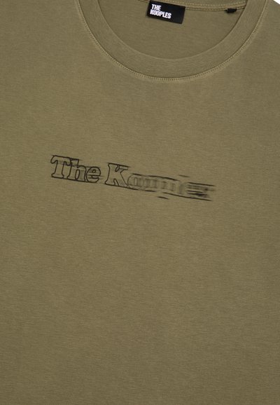 Camiseta de algodón color verde olivo con cuello redondo y el logo de "The Kooples" en negro, estilo difuminado, en el pecho.