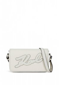Biała skórzana torebka na ramię z wyraźnym wytłoczonym logo "Karl" z przodu, wyposażona w odpinany pasek i gładką fakturę.
